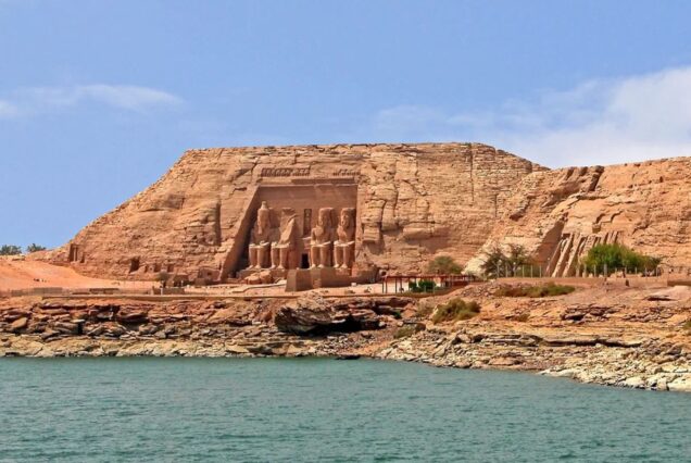 View of the colossal statues at the entrance of Abu Simbel temple complex with clear skies above