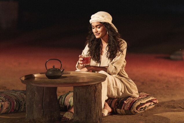 Woman enjoying tea at an outdoor setting in the desert