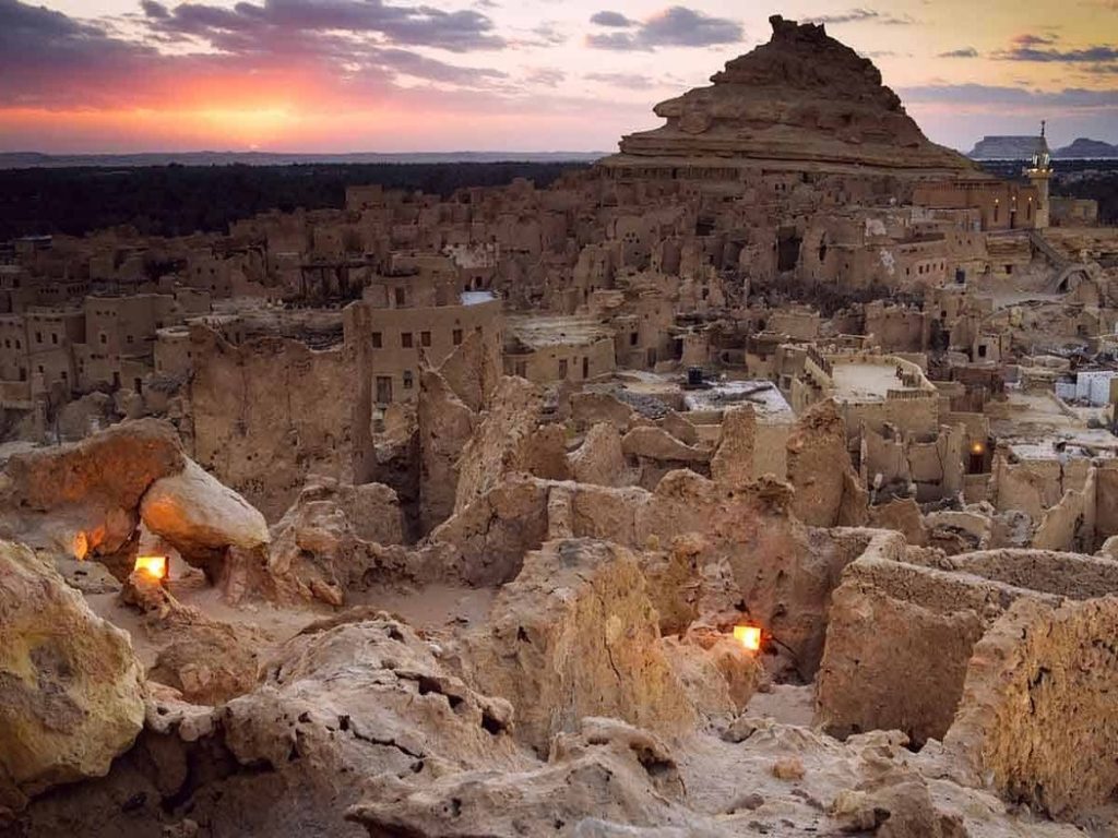 Panoramic view of Siwa Oasis with lush greenery and rugged mountains in the distance.