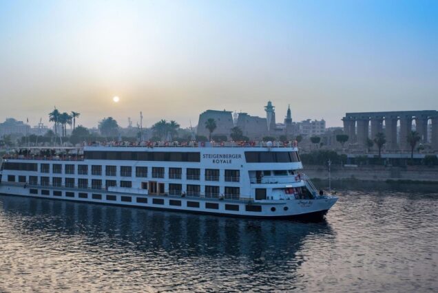 Luxury cruise ship Steigenberger Royale sailing along the Nile River at sunrise with a view of ancient temples