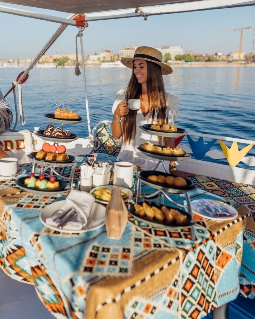 Woman enjoying tea and pastries on a boat on the Nile