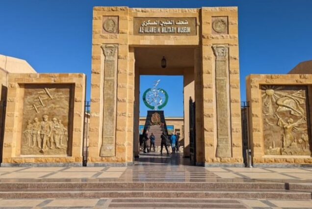 The entrance to the Al-Alamein Military Museum, with large stone carvings and a memorial in the background