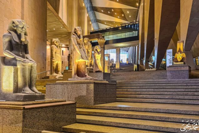 Interior of a museum with large statues of Egyptian pharaohs on display