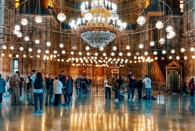 Interior of the grand Mosque of Muhammad Ali in Cairo, illuminated with golden chandeliers