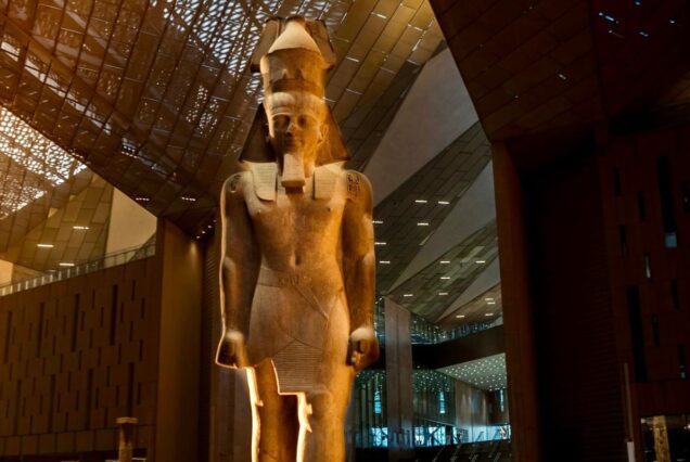 Large statue of an ancient Egyptian pharaoh inside a museum