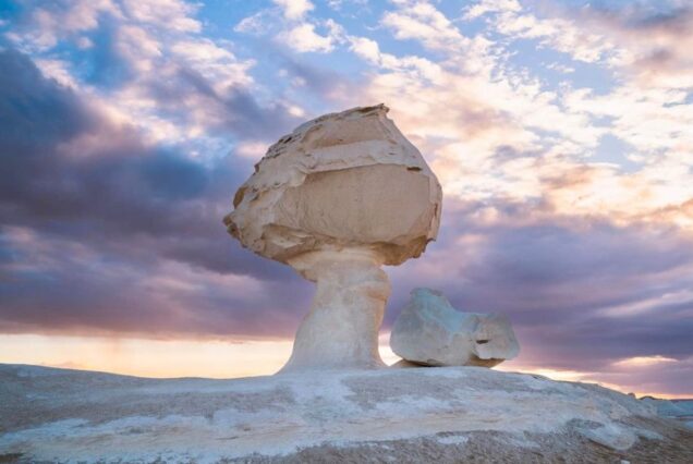 A unique mushroom-shaped rock formation in Egypt’s White Desert at sunset