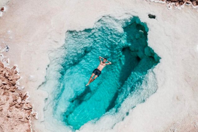 A man floating in a natural saltwater pool in the Egyptian desert