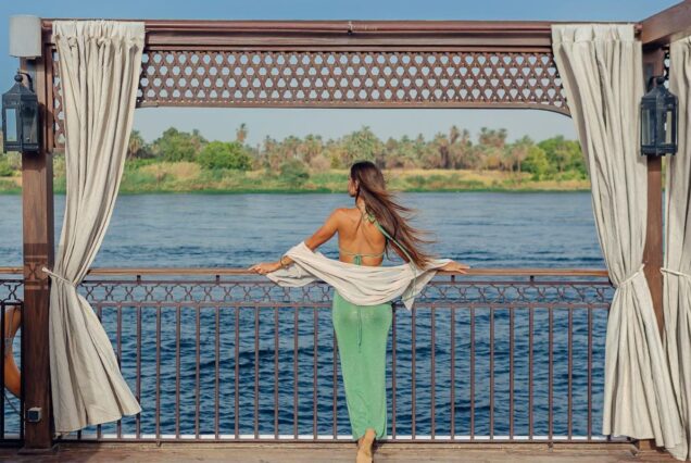 A woman looking at traditional felucca sailboats on the Nile River