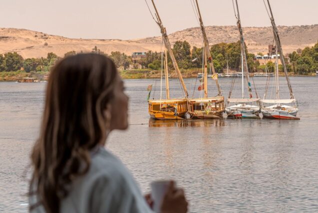 A woman looking at traditional felucca sailboats on the Nile River