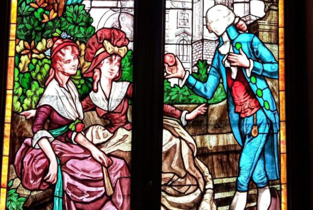 Vintage stained glass window depicting historical figures in a garden scene