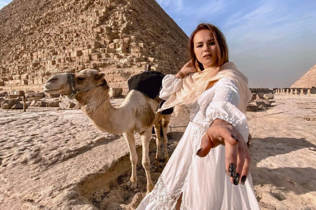 Woman with a camel in front of the Great Pyramid in Egypt