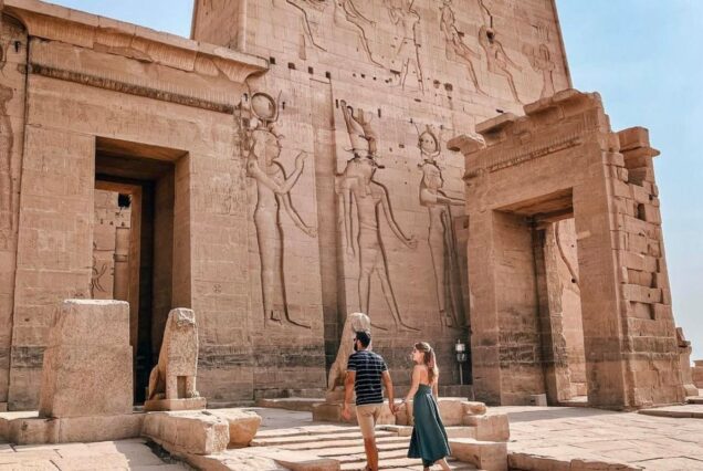 The Colossi of Memnon in Luxor, Egypt, two massive stone statues standing tall against a clear sky