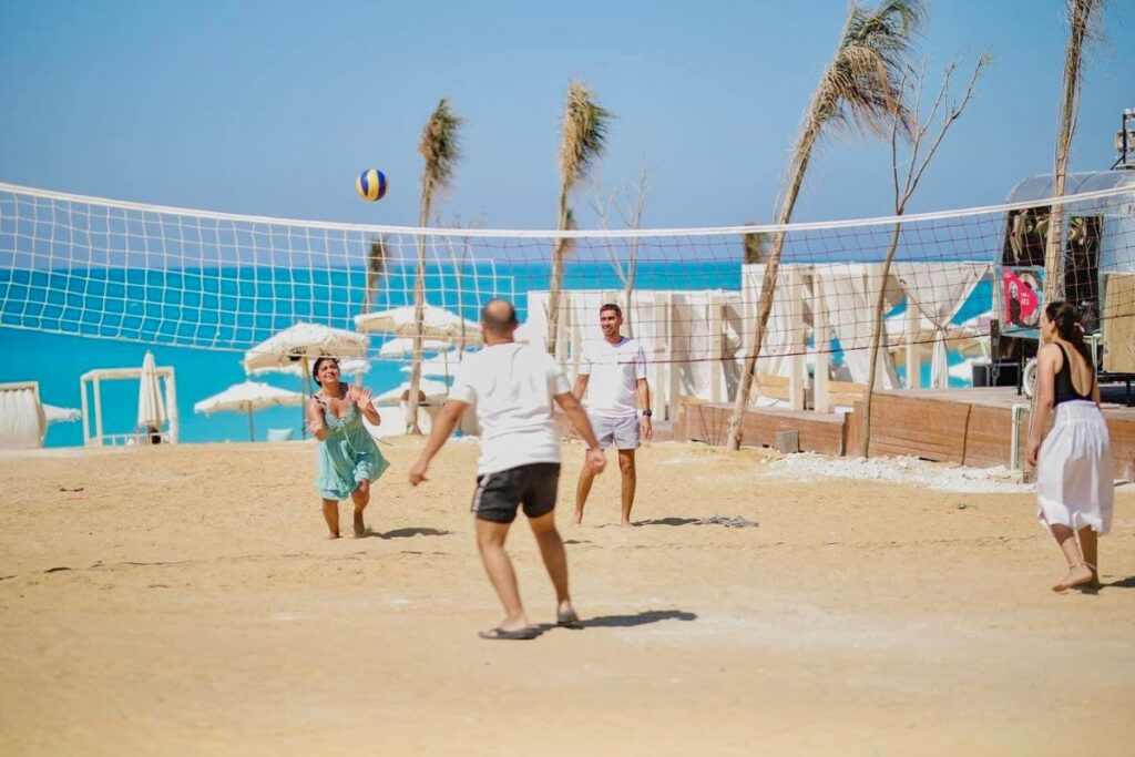 Group playing beach volleyball on a sandy shore