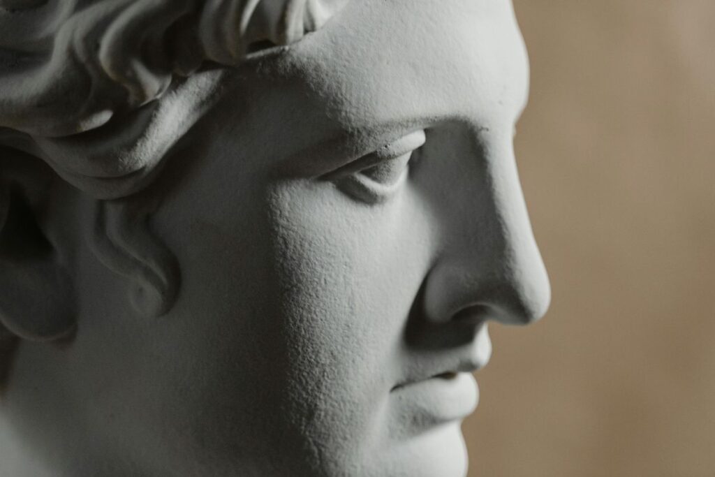 Classical marble bust of an ancient figure against a dark background