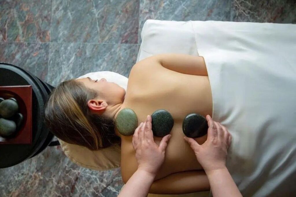 Hot stones placed on a client’s back during a spa treatment