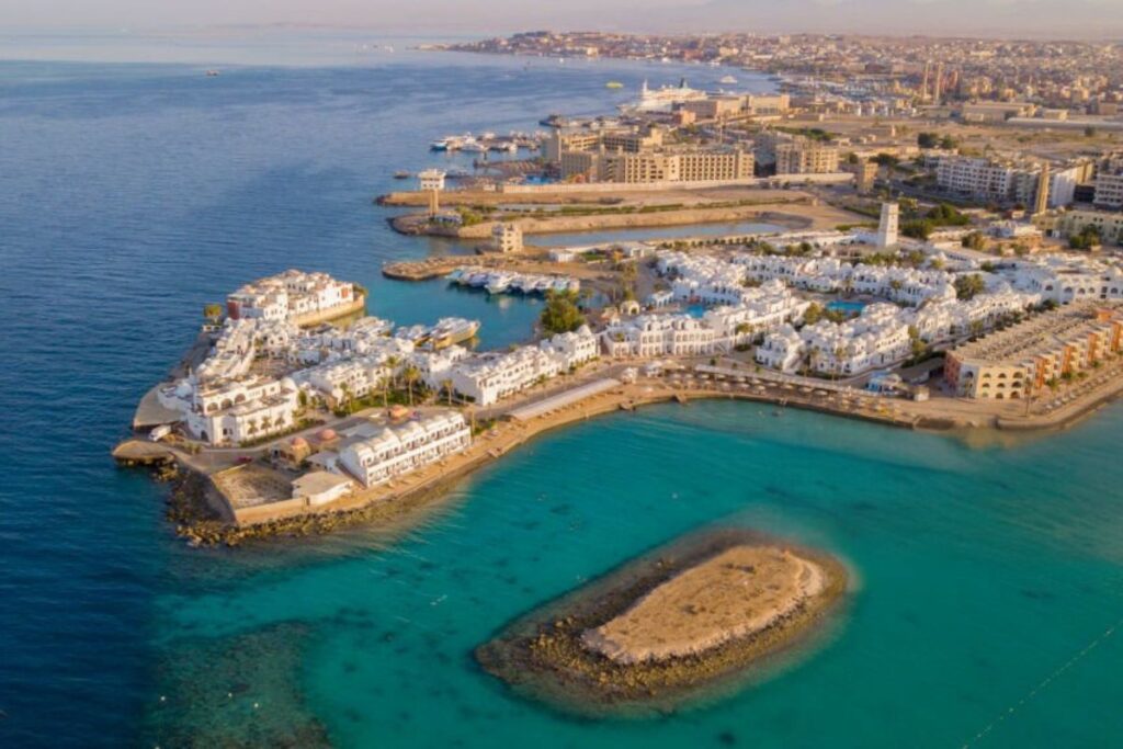 Aerial view of a luxurious seaside resort with white buildings and turquoise waters