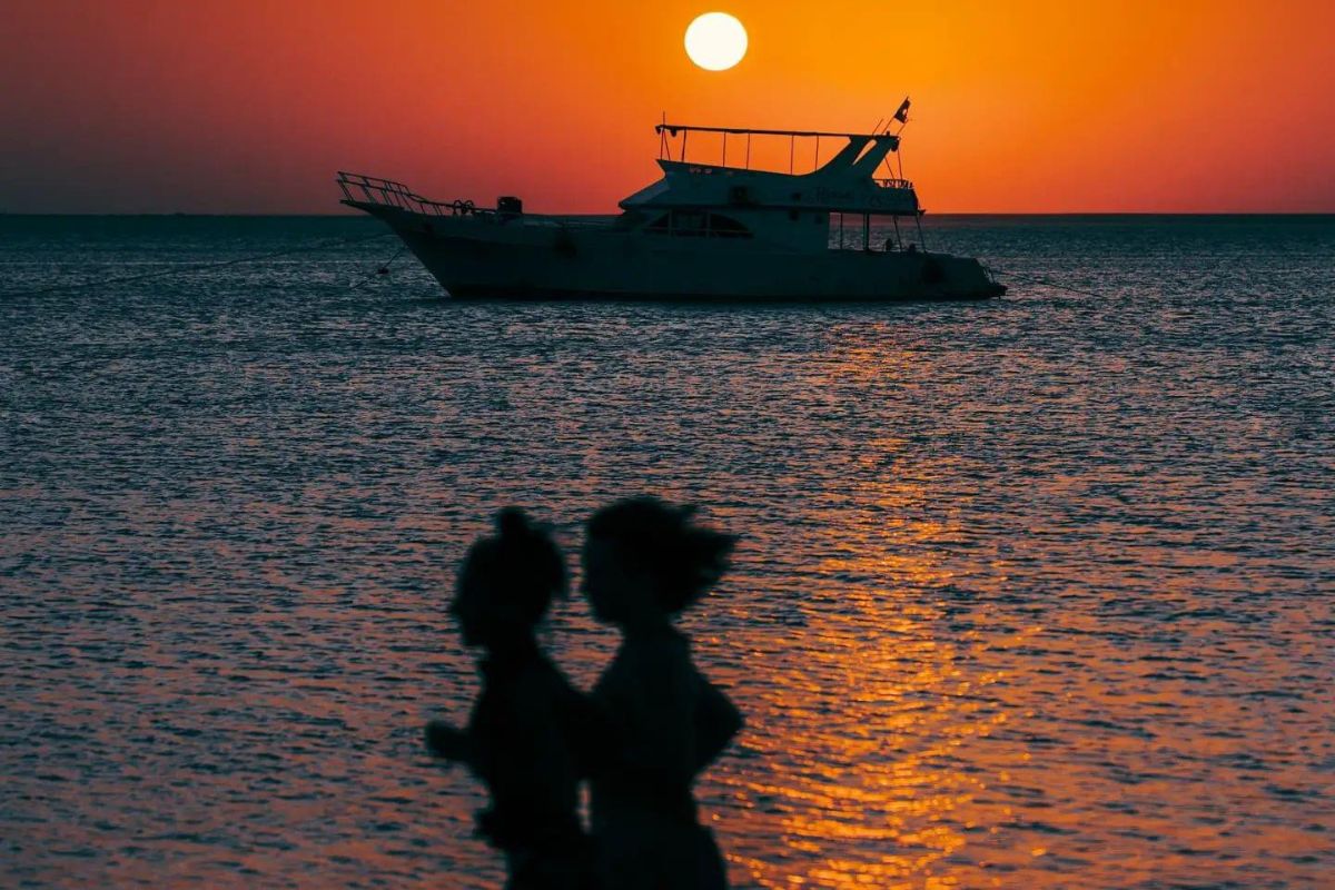 Silhouetted boat at sunset on the ocean